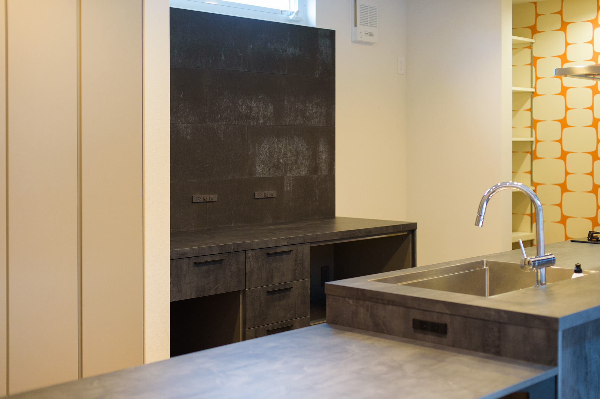 外壁に採用したKmewのSOLIDOを、室内の玄関やキッチンにもSOLIDO＜鉄黒＞を贅沢に使用する...